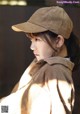 A woman wearing a brown corduroy baseball cap.