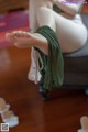 A woman sitting on top of a chair with her feet up.