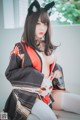 A woman in a kimono sitting on a window sill.