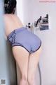 A woman in a gray panties is taking a shower.