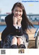 A young woman sitting on the ground next to a bike.